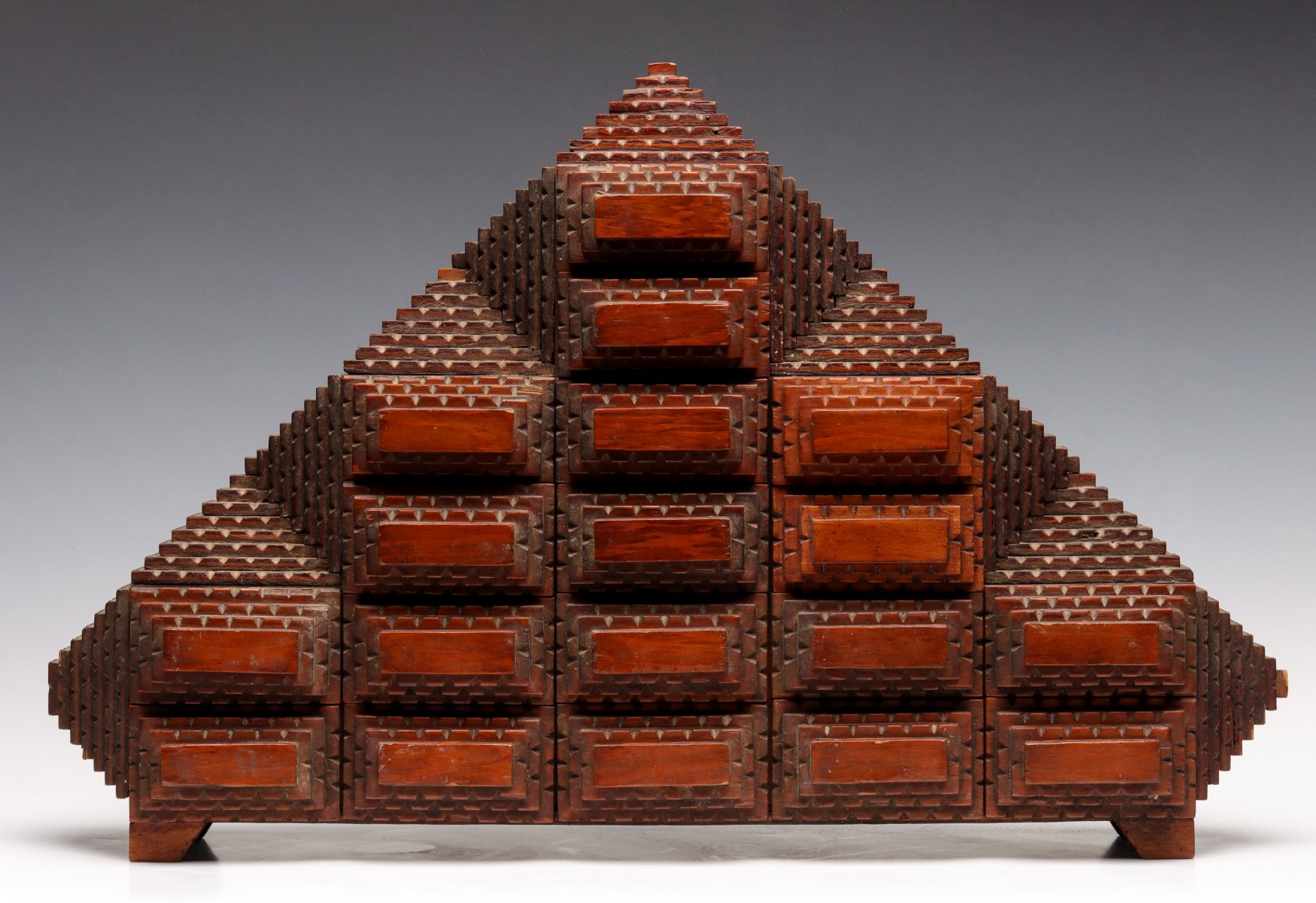 AN UNUSUAL PYRAMIDAL FORM TRAMP ART CASE OF DRAWERS