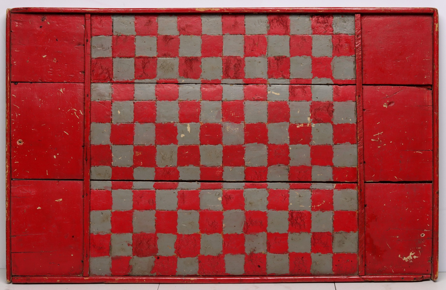 A PRIMITIVE 19C. AMERICAN GAME BOARD ON OLD PAINT