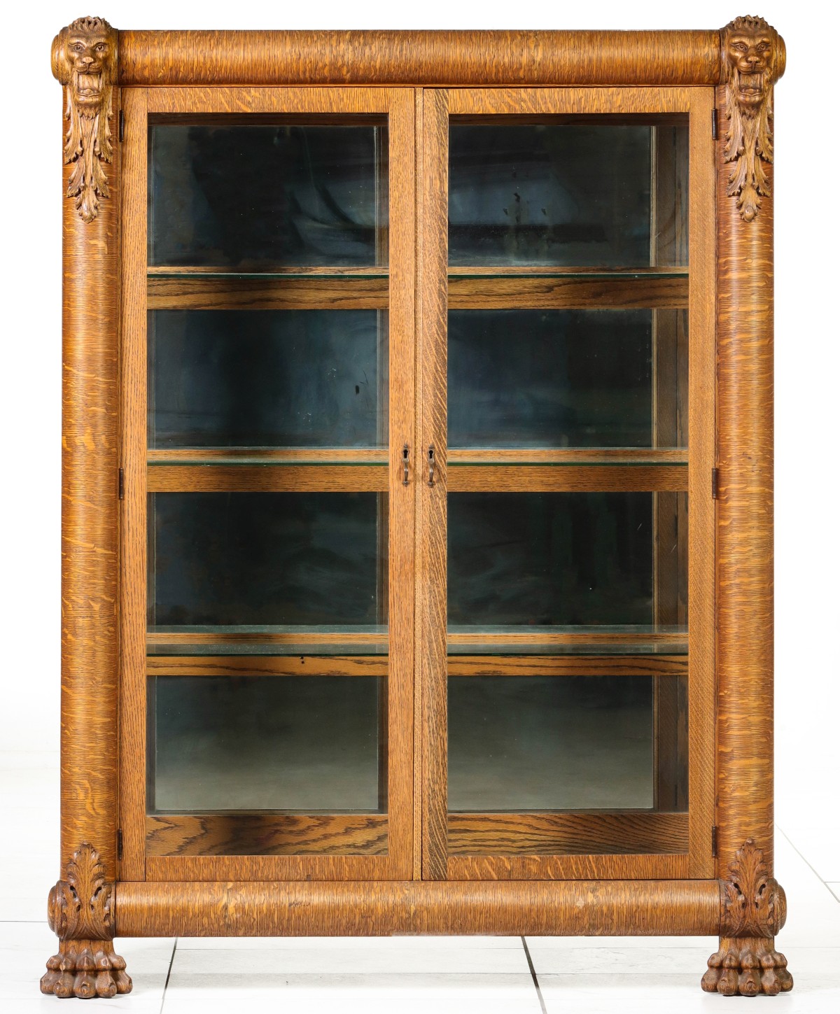 AN EARLY 20TH CENTURY OAK BOOKCASE WITH LION'S HEADS