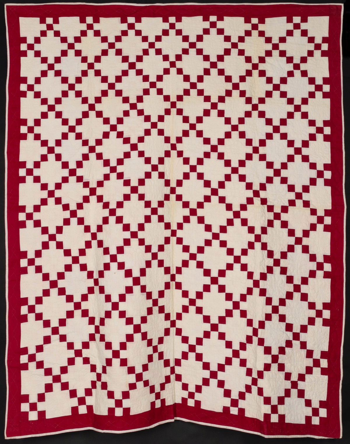 A RED AND WHITE IRISH CHAIN HAND STITCHED QUILT