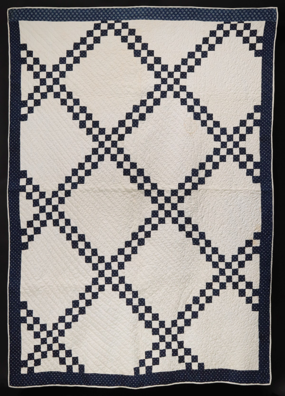 A BLUE AND WHITE IRISH CHAIN PATTERN QUILT