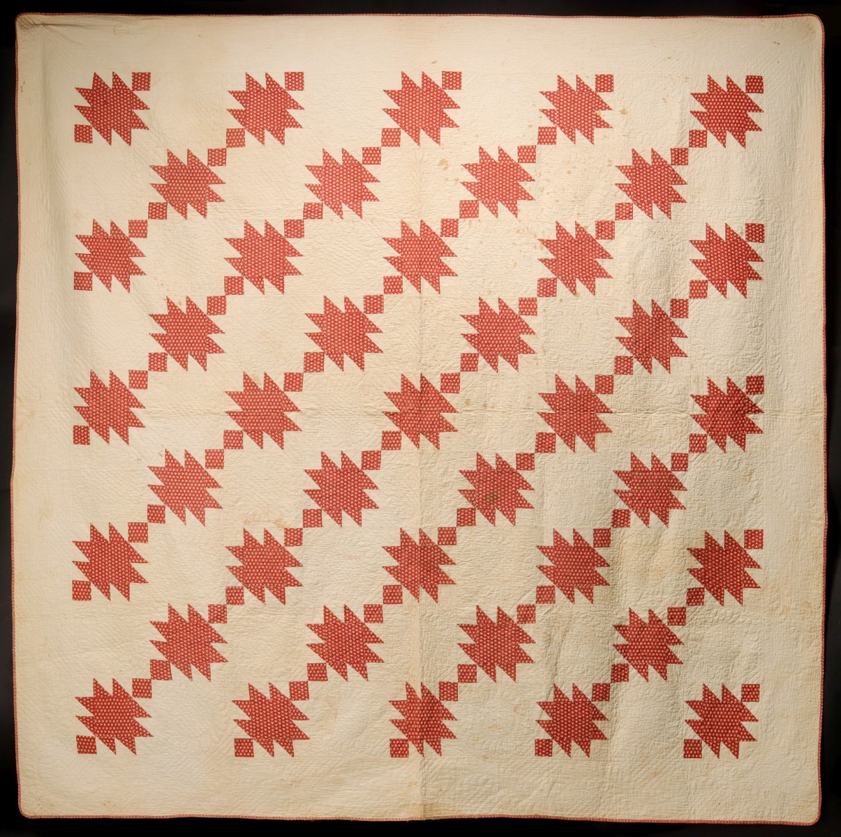 A 19TH CENTURY RED AND WHITE ANVIL PATTERN QUILT