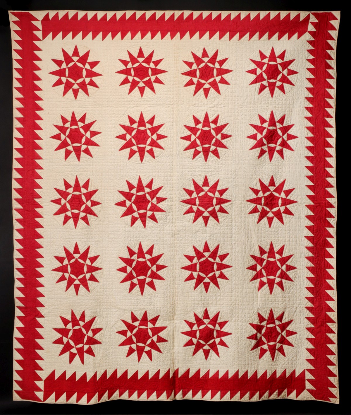 A MARINER'S COMPASS PATTERN QUILT IN RED AND WHITE