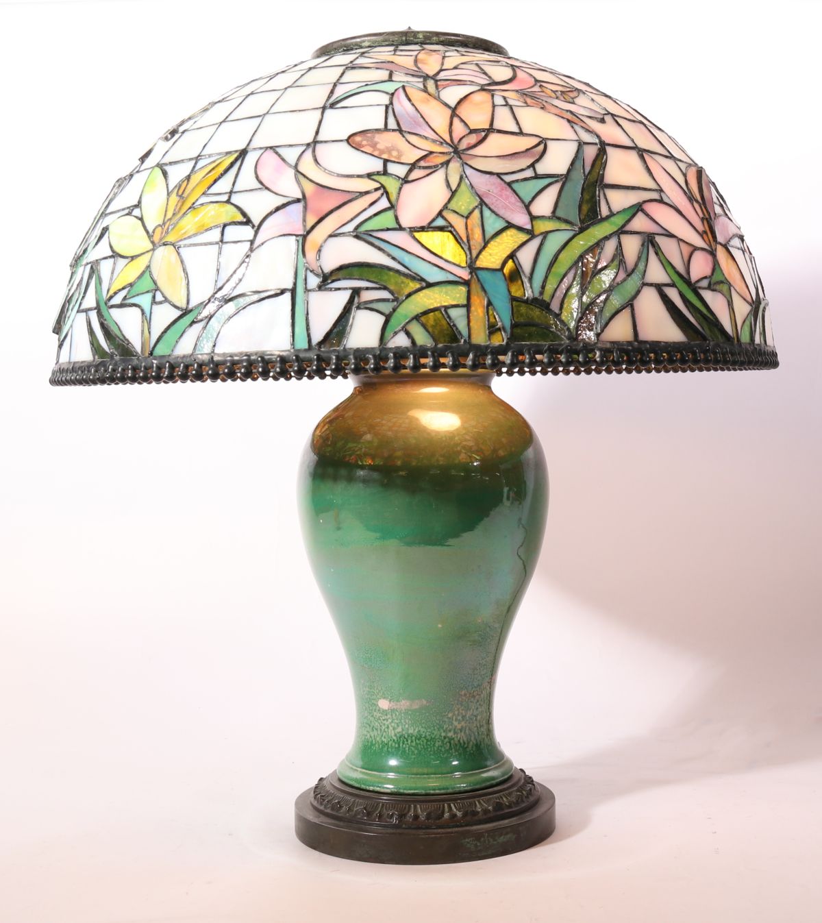 A CONTEMPORARY STAINED, LEADED LAMP ON PORCELAIN BASE