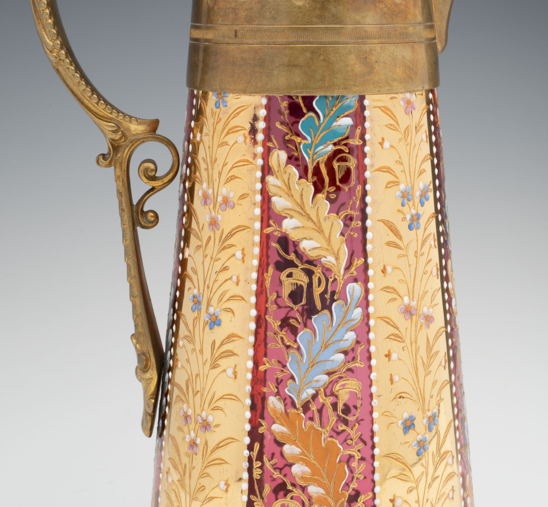 A MOSER GILT AND ENAMEL JUG WITH BRASS MOUNTS