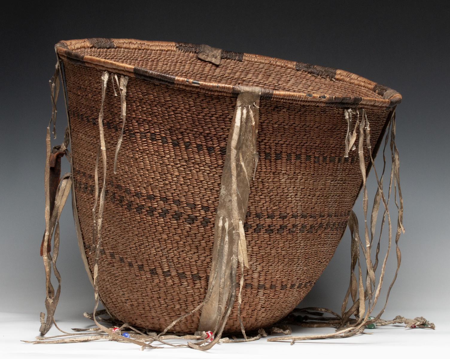 A GOOD 19TH CENT APACHE BURDEN BASKET WITH RAWHIDE