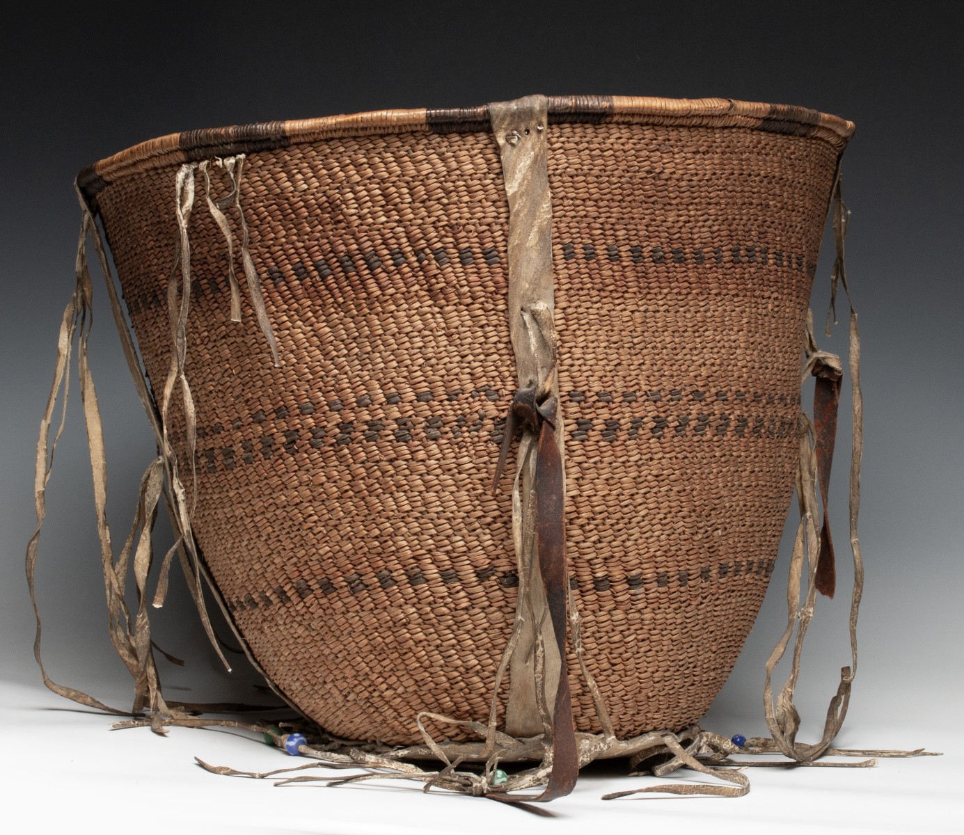 A GOOD 19TH CENT APACHE BURDEN BASKET WITH RAWHIDE