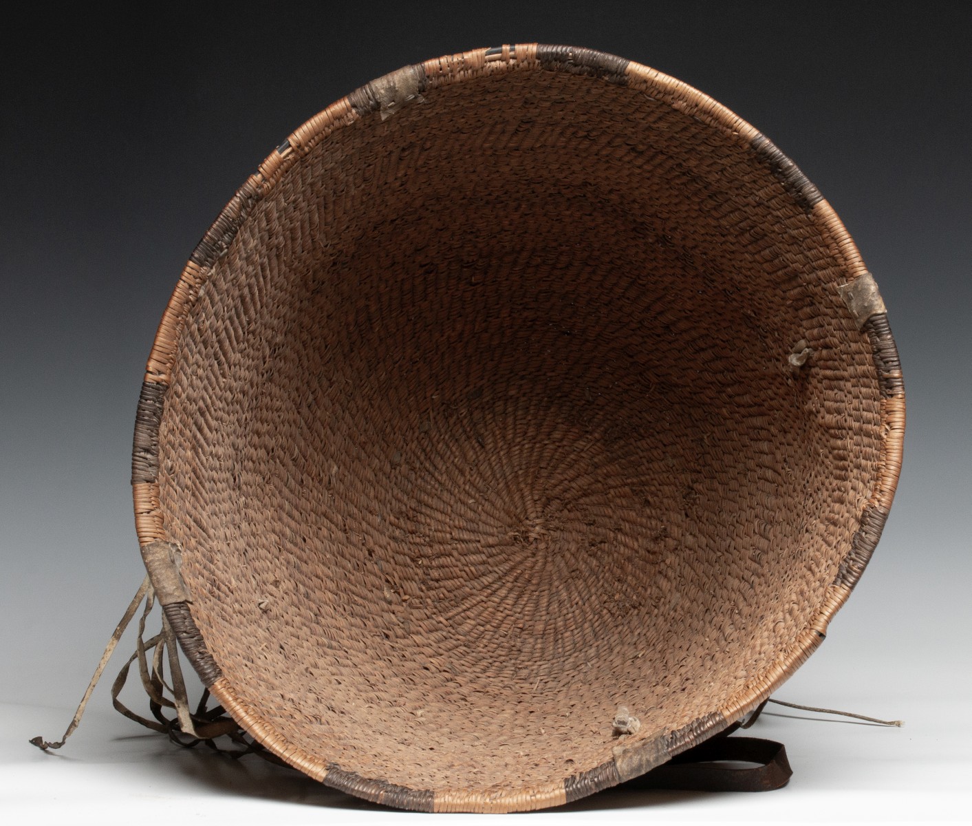 A GOOD 19TH CENT APACHE BURDEN BASKET WITH RAWHIDE