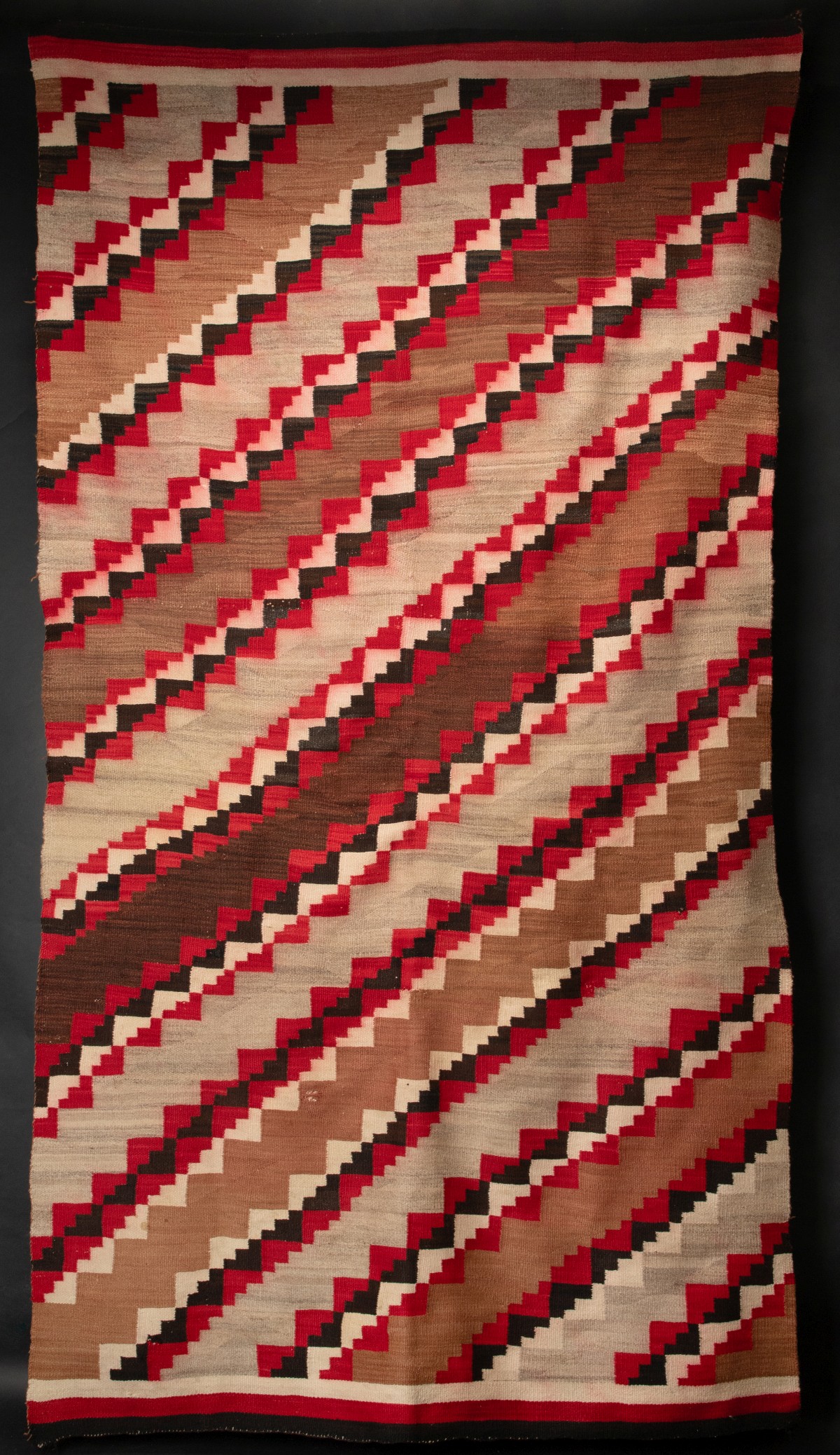 A LARGE 9 X 4 NAVAJO RUG WITH DIAGONALS AND BANDED ENDS