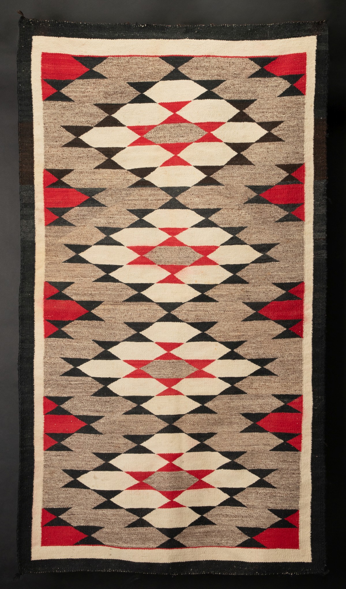 A NAVAJO GANADO RUG WITH LARGE STEPPED DIAMONDS