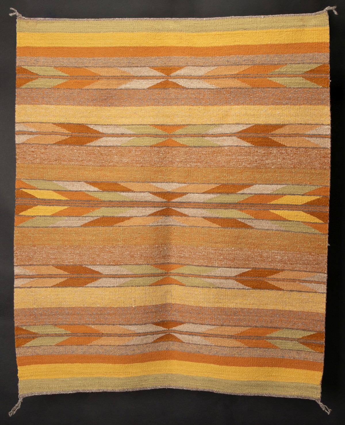 A VEGETAL DYE NAVAJO CRYSTAL RUG WITH FEATHER MOTIF