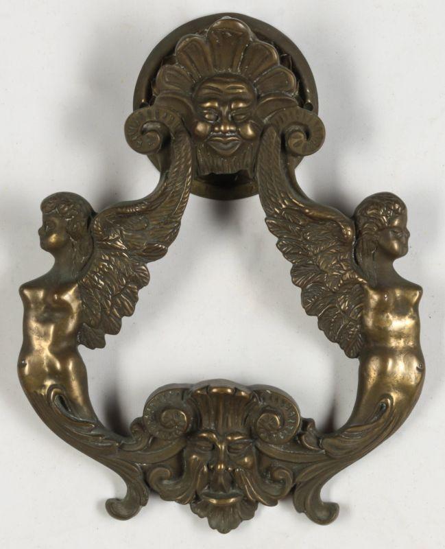 A MASSIVE BRASS DOOR KNOCKER WITH WINGED FIGURES 