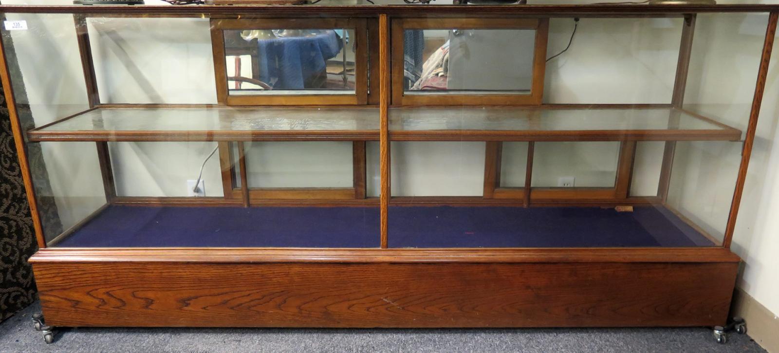 AN ANTIQUE OAK FLOOR MODEL SHOWCASE EIGHT FEET LON